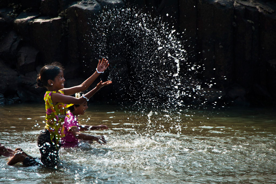 Children play with river water by Astro Mohan